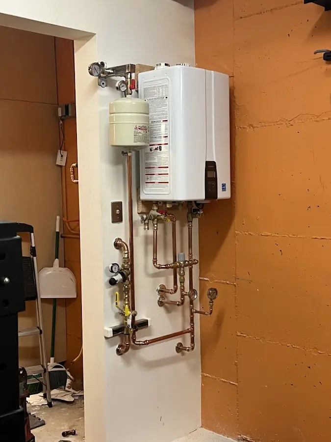 Plumbing technician inspecting water heater connections in Red Hill